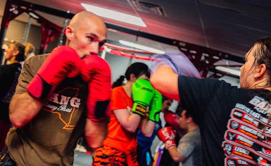 Coach Joee, a BANG striking system black belt, holding a tight boxing guard while his partner throws a jab during boxing class at ATT Watertown